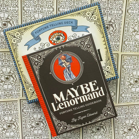 Maybe Lenormand kortų rinkinys su vadovu juodu viršeliu ir raudona nugarėle, gulsčiai ant kortų galų dekoruotos įpakavimo