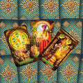 Tarot kortos — trys Pentaklių kortos atverstos ant mėlyno ir auksinio ornamentuoto nugarėlio, artimas kampas
