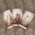 tarot kortos su trimis Pentaklių figūromis — riteris ant žirgo centre, sėdinčios ir stovinčios moterys šonuose, sepijos tonai