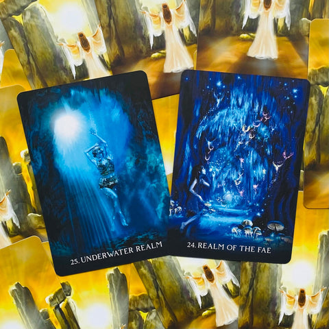 Tarot kortos su mėlynomis iliustracijomis priekyje (25 Underwater Realm, 24 Realm of the Fae) ir geltonu atgalu, kontrastingos kolekcijoje