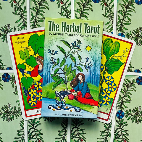 Tarot kortos The Herbal Tarot dėžutė su dviem spalvotomis kortomis ant žolelių raštuoto fono