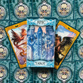 Tarot kortos Epic dėžutėje su mėlynais ornamentais ir auksiniais rėmeliais bei dviem iliustruotomis kortomis šonuose