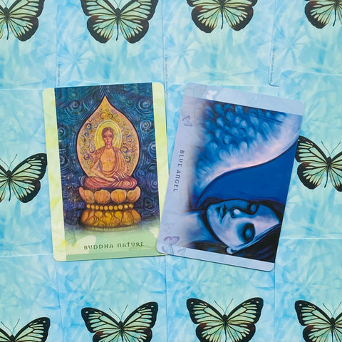 Orakulų kortos Blue Angel ir Buddha Nature, dvi priekinės kortų pusės mėlyname fone su drugeliais, ryškios spalvos