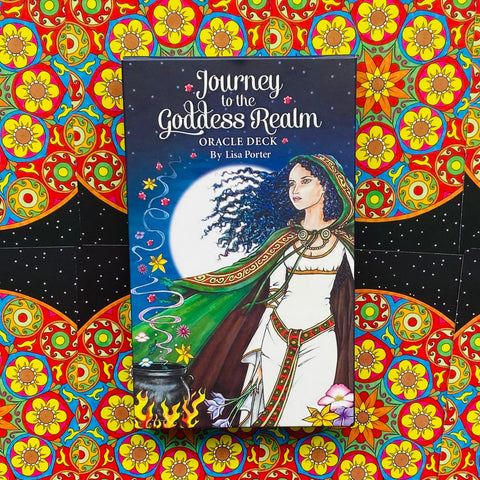 Orakulo kortų rinkinys „Journey to the Goddess Realm“ dėžutė (Lisa Porter), prie ryškaus ornamentinio fono, priekinis vaizdas