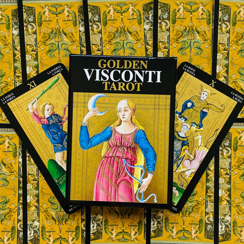 Golden Visconti tarot rinkinys su juodu dėklu ir trijų auksinių iliustruotų kortų ventiliatoriumi, dekoratyviame fone