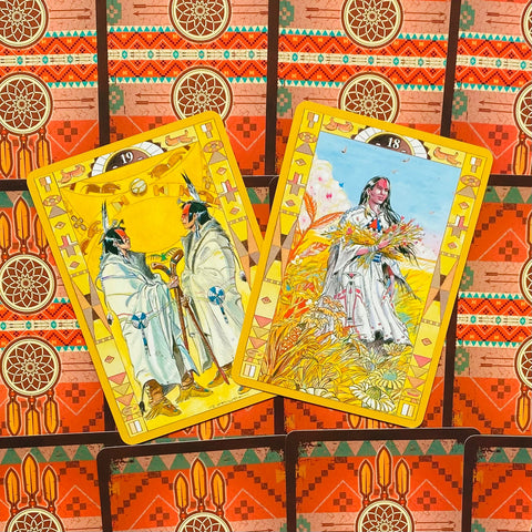 Tarot kortos geltonu kraštu: dvi atviros kortos su indėniškai įkvėptomis iliustracijomis – pokytis ir derlius, kito komplekto fone