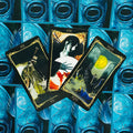 Tarot kortos fanuotos trijų atvirų kortų rinkinys su tamsiais rėmeliais ir ryškiomis mėlynomis nugarėlėmis