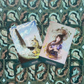 Tarot kortos su dviem atverstomis kortomis (Release ir Raven's Wand) ant žalio ornamentuoto fono, kampu išdėstytos