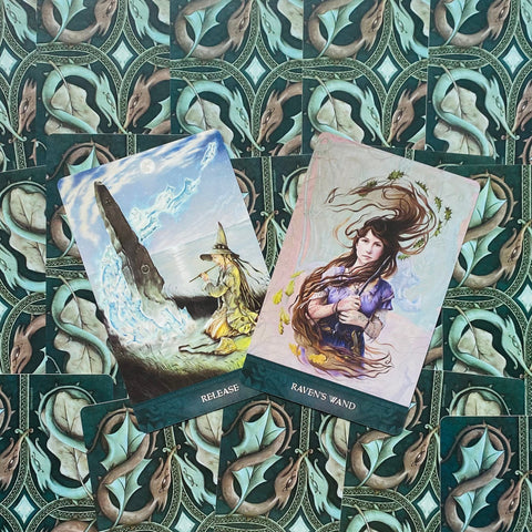 Tarot kortos su dviem atverstomis kortomis (Release ir Raven's Wand) ant žalio ornamentuoto fono, kampu išdėstytos