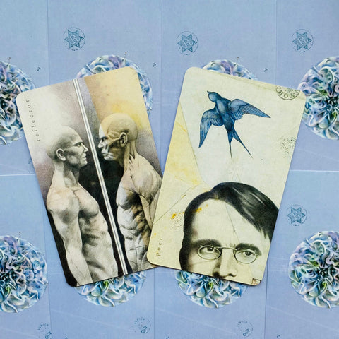 Tarot kortos su iliustracijomis: dvi atviros kortos (Reflector ir Poet) demonstruoja detalius pieštus portretus ir mėlyną foną, skirtos kolekcijos variantui