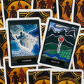 Tarot kortos su baltu rėmeliu: dvi atverstos kortos „Illusions“ (mėlyna) ir „Growth“ (žalia su rože) ant raštuoto fono, matomas kortų priekis