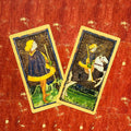 Tarot kortos Marseille stiliaus – dviejų Lazdų kortų artimas kadras su geltonais akcentais ant nusidėvėjusio raudono fono, unikalus variantas