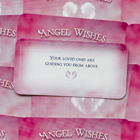 Angel Wishes kortelė, rožinė orakulo kortelė su anglišku užrašu "Your loved ones are guiding you from above" ir mažais angelų sparnais, artimas kampas