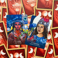 Tarot kortos dvi atverstos Lalita ir Lakshmi kortos su ryškiomis mėlynomis ir raudonomis iliustracijomis, mėnulio nugarėlės fone
