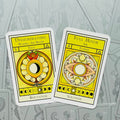 Tarot kortos geltonomis mėnulio iliustracijomis — dvi atverstos kortos (Disseminating ir Full Moon) ant pilko raštuoto fono