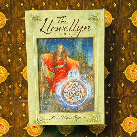 Llewellyn tarot kortų rinkinys: smėlio spalvos dėžutė su raudonai apsirengusios moters iliustracija ir autorės parašu