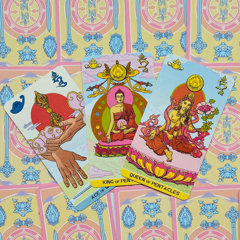 Tarot kortos pastelinės, trys atverstos kortos (Ace of Wands, King ir Queen of Pentacles) išdėstytos ant raštuoto nugarėlių fono
