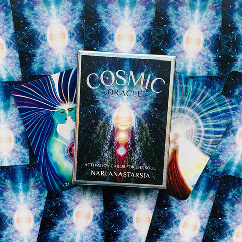Cosmic Oracle kortos Nari Anastarsia su mėlynomis kosminėmis iliustracijomis, dėžutė centre ir atverstos kortos vėduoklė