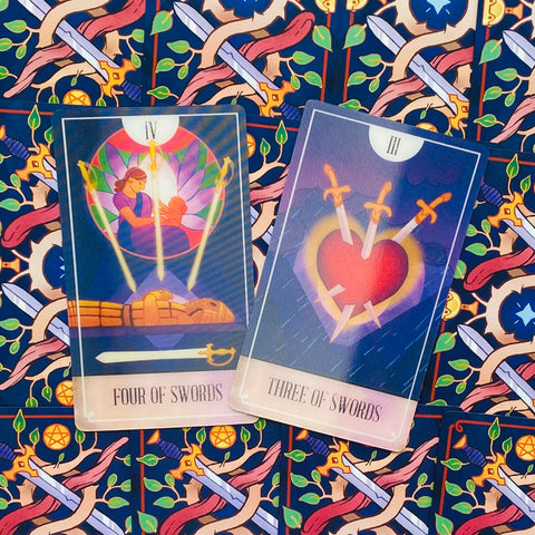 Tarot kortos su Keturių kardų ir Trijų kardų iliustracijomis, pateiktos ant spalvingo ornamentuoto nugarėlės fono