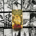 tarot kortos Secret Forest — geltonai žalsva dėžutė stovinti ant juodai baltų iliustruotų kortų, akcentuoja viršelio meną