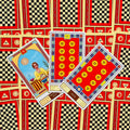Tarot kortos su ryškiai raudonomis nugarėlėmis ir languotu piešiniu, trijų kortų išdėstymas su monetų rūšies kortomis