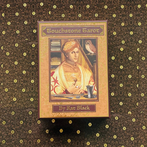Tarot kortos Touchstone (Kat Black) – rožinė auksinė dėžė, matomas dėžės priekis su renesansine iliustracija ir autoriaus vardu
