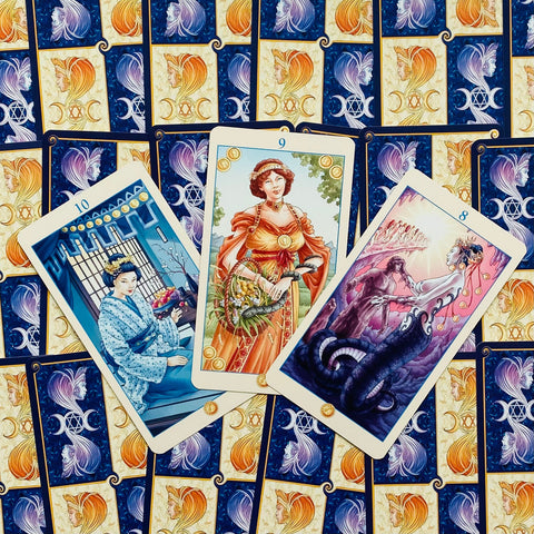 Tarot kortos su mėlyno ir auksinio rašto nugarėlėmis, trijų kortų išdėstymas (8, 9, 10) su detaliomis iliustracijomis