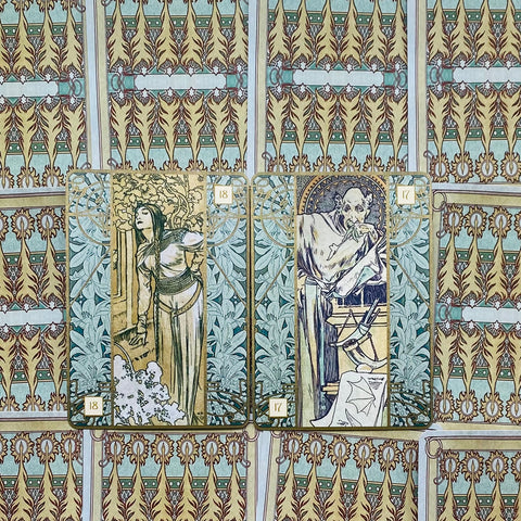 Tarot kortos Alphonse Mucha stiliaus iliustracijomis, dvi kortos (18 ir 17) žalių ir auksinių ornamentų fone, artimas produktų rodinys