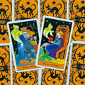 Tarot kortos Ghosts komplektas, atverstos Karalius ir Karalienė, dėmesys į spalvingas iliustracijas ir oranžines juodas nugarėles