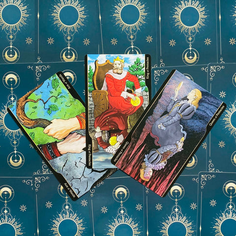 Tarot kortos komplektas: trys atverstos kortos (Karalius ir Karalienė Pentaklių, Lazdų tūzas) ant tamsiai mėlyno žvaigždėto fono, plokščias išdėstymas