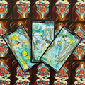 Tarot kortos Pentaklių rūšies – trys akvarelinės kortos (karalius, princesė, princas) žaliai‑mėlynos, išdėstytos ant samurajaus nugarėlių su jin‑jan simboliu