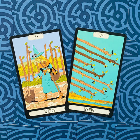 tarot kortos — du Wands kortų variantai: kairėje moteris su katinu mėlyname kostiume, dešinėje skriejančios lazdelės ant mėlyno labirinto fono