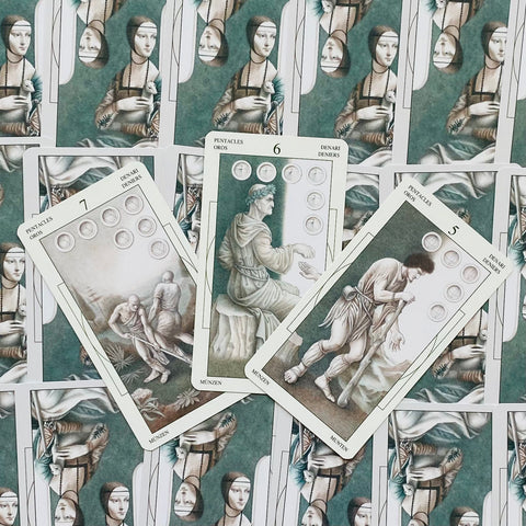 Tarot kortos žalio‑kremų fono Pentacles komplektas, trijų kortų priekinis išdėstymas su matomais monetų simboliais, skirtas variantui parodyti