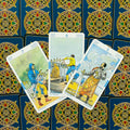 Tarot kortos trijų kardų derinys (5,6,7) iš viršaus ant mėlynos ornamentuotos nugarėlės, skirta trijų kortų išklotai