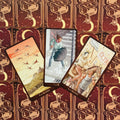 Tarot kortos fanuotos ant bordo nugarėlių su mėnulio motyvais, matomos 8, 7 ir 6 lazdelių kortų iliustracijos