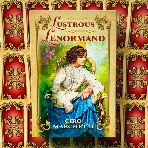 Lenormand kortų rinkinys Lustrous (Ciro Marchetti) — aukso-raudonas priekinis dangtelis su moterimi mėlynoje suknele, galerijos pavyzdys