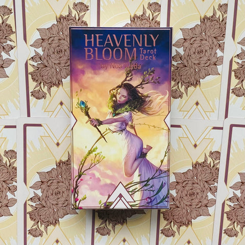 Produktų puslapyje – priekinis Heavenly Bloom tarot kortų dėžutės viršelis, centrinis stačiakampis kadras su pasteline rožine ir auksine gėlių fono kortele