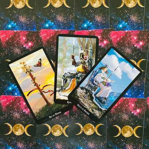 Tarot kortos — trijų kortų komplektas (Ace of Wands, Karalius, Kardų karalienė) atverstas ant mėnulio ir kosmoso raštuoto fono