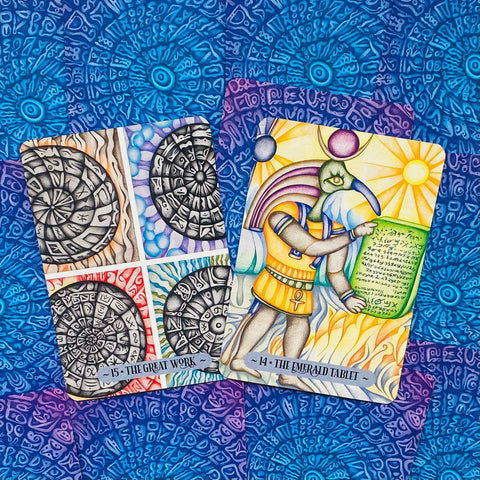 tarot kortos su spalvingu „The Emerald Tablet“ paveikslu ir keturiomis juodai baltomis „The Great Work“ vignietėmis ant mėlyno raštuoto fono