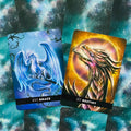 tarot kortos su drakonų iliustracijomis: mėlyna XVI Grace ir auksinė XV Destiny ant žvaigždėto fono, žiūrima iš viršaus