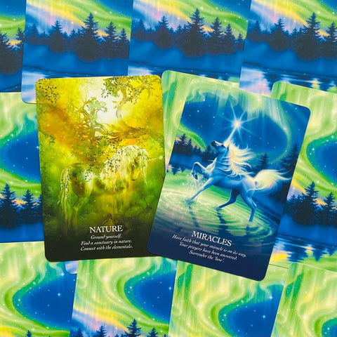 Kortos: du atviri oracle variantai — žalia „Nature“ ir mėlyna „Miracles“ ant švytinčio šiaurės pašvaistės fono