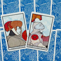 Tarot kortos – dvi atviros Pentaklių kortos (Page ir Knight), rodomos įstrižai, priekiniai piešiniai ir mėlynas nugarėlių raštas matomi