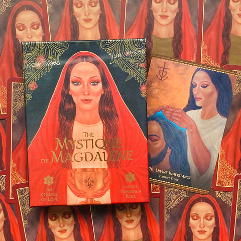 Orakulo kortų rinkinys The Mystique of Magdalene raudoname dėkle, dėžutės priekyje ir viena atversta korta šone