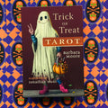 Tarot kortos Trick or Treat, Barbara Moore leidimas su tamsiai raudonu viršeliu, vaiduoklio iliustracija, moliūgo krepšeliu ir rožiniais batais, centrinis viršelis