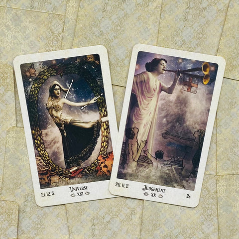 tarot kortos dviejų kortų rinkinys su Universe ir Judgement dizainais, kreminėmis kraštinėmis, retro iliustracijomis ir pasviru išdėstymu