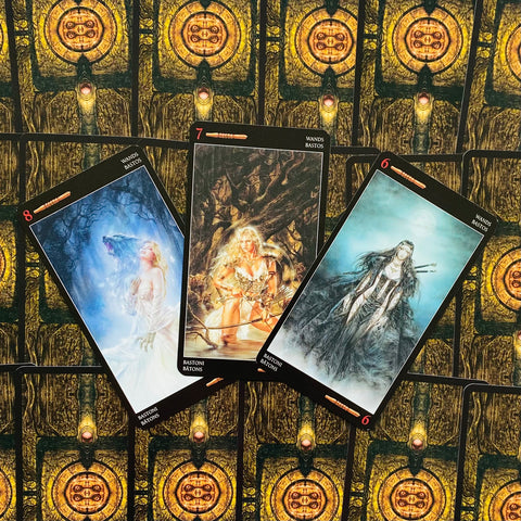 tarot kortos rinkinys su trimis atverstomis Bastoni (Wands) kortomis ant ornamentuoto auksinio fono