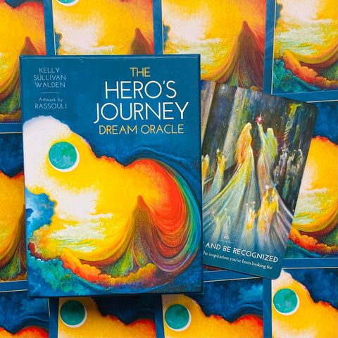 Orakulų kortos The Hero's Journey Dream Oracle mėlyname dėkle su atversta korta, ryškiais geltonais ir geltonai mėlynais meniniais motyvais