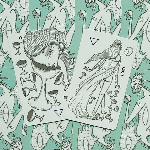 tarot kortos su rankų piešiniais — atvirti 8 ir 9 taurės variantai, gulintys ant mėtų atspausto nugarėlių, skirtos taro skaitymams