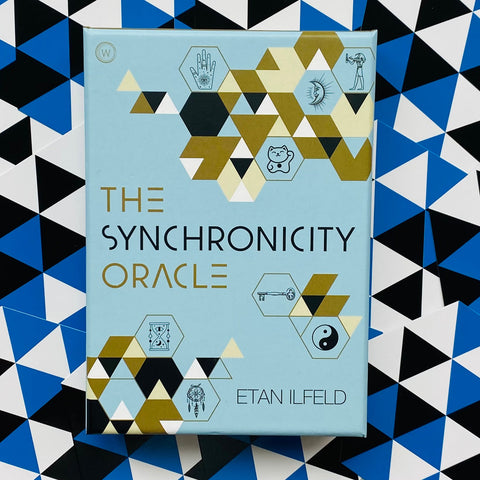 Synchronicity Oracle kortų rinkinys Etan Ilfeld, šviesiai mėlyna dėžutė iš priekio su auksinėmis ir juodomis geometrinėmis figūromis ant trikampio fono