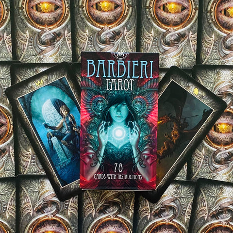 Barbieri Tarot dėžutė centre (žalsvai rausvas viršelis, 78 kortos), dvi atverstos kortos ant dekoratyvaus kortų fono